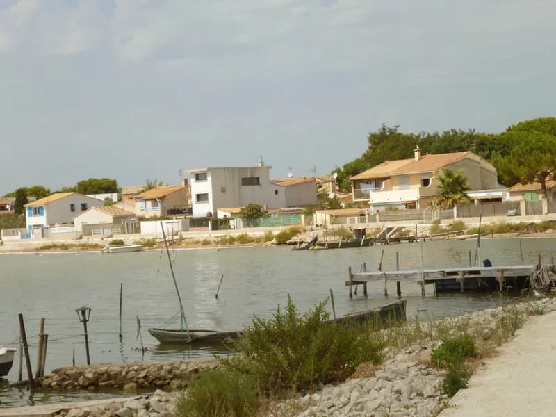 Maisons des cabanes de Pérols au ras de l'eau, barques et ponton sur l'étang de l'Or